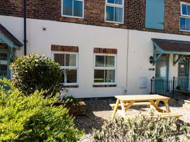 An outdoor area with a bench and bushes at Chestnut Cottage in Bridlington