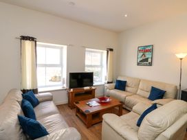 A living room with a television and seating arrangements at Chestnut Cottage in Bridlington