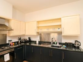 A kitchen with cabinets, sink, cooktop and appliances at Chestnut Cottage in Bridlington
