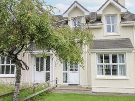 A house exterior with a tree and front door at 22 White Maples in Bundoran, County Donegal