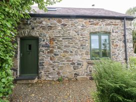 An exterior view of a stone cottage with a green door at The Dovecote near Fishguard