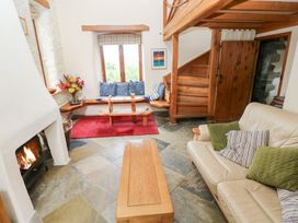A living room with a fireplace and seating area at The Dovecote in Llanychaer near Fishguard