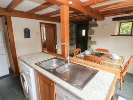 A kitchen with a sink and dining area at The Dovecote in Llanychaer near Fishguard