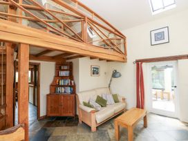 A living room with a sofa, coffee table, and bookshelf at The Dovecote near Llanychaer Fishguard
