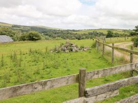 An outdoor scene with a field, solar panels, and a fence at The Dovecote near Llanychaer Fishguard