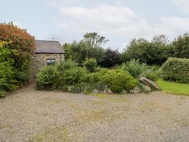 A stone building surrounded by gravel and plants at The Dovecote in Llanychaer near Fishguard