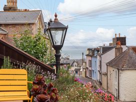 A view of houses and flowers with a lamp post in Captains Cottage in Brixham
