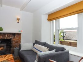 A living room with a sofa and fireplace at Captains Cottage in Brixham