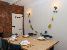 A dining room with a table set for meals at Captains Cottage in Brixham