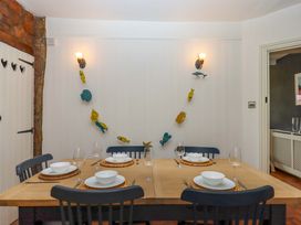 A dining room with a wooden table set for a meal at Captains Cottage in Brixham