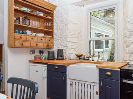 A kitchen with a sink and shelves at Captains Cottage in Brixham