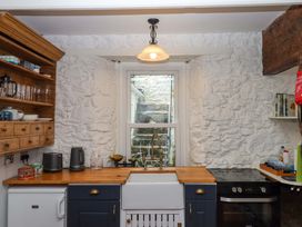 A kitchen with a sink and stove at Captains Cottage in Brixham