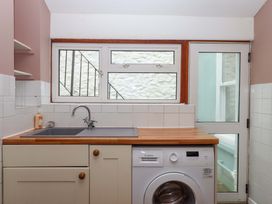 A kitchen with a sink and washing machine at Captains Cottage Brixham
