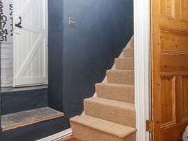 A hallway with stairs and a door at Captains Cottage in Brixham