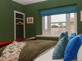A bedroom with a bed and window at Captains Cottage in Brixham