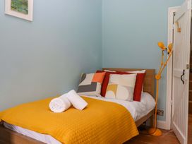A bedroom with a bed and lamp at Captains Cottage in Brixham