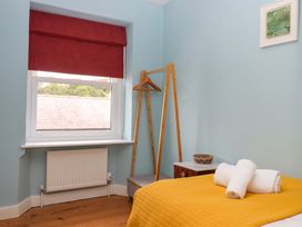A bedroom with a bed and towels at Captains Cottage in Brixham