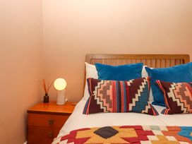 A bedroom with a bed and bedside table at Captains Cottage in Brixham