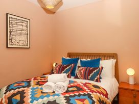 A bedroom with a bed and artwork on the wall at Captains Cottage in Brixham