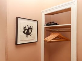 A closet with hangers and a hair dryer at Captains Cottage in Brixham