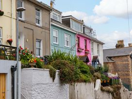 A row of colorful houses with flowers in pots at Captains Cottage Brixham
