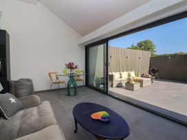 A living room with a glass door leading to an outdoor seating area at Noflash Malpal in Bristol
