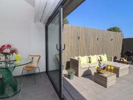 An outdoor seating area with a glass table and sofa at Noflash Malpal in Bristol