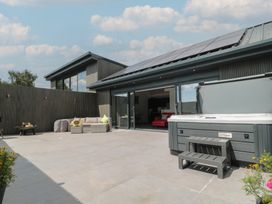 An outdoor area with a hot tub and seating at Noflash Malpal in Bishop Sutton