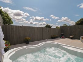 An outdoor area with a hot tub and patio furniture at Noflash Malpal in Bishop Sutton