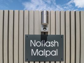 A sign with the name Noflash Malpal against a wooden wall in Bishop Sutton