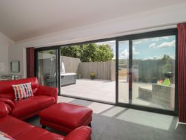 A living room with a sliding glass door leading to an outdoor patio at Noflash Malpal in Bishop Sutton