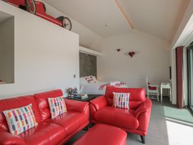 A living room with red furniture and a bed in Noflash Malpal in Bishop Sutton