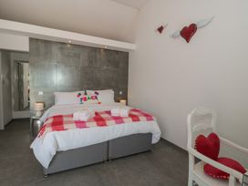 A bedroom with a bed and chair at Noflash Malpal in Bishop Sutton