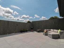 A patio with a sofa and barbecue grill at Noflash Malpal in Bishop Sutton