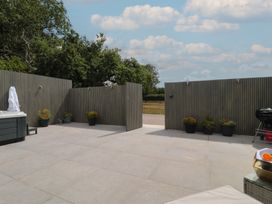 An outdoor area with a hot tub and flower pots at Noflash Malpal in Bishop Sutton