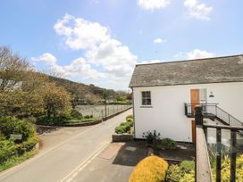 A view of a building and road with trees at Tater-Du in Porthcurno