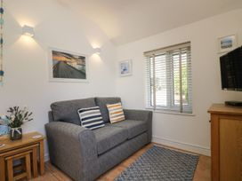 A living room with a sofa and TV at Tater-Du in Porthcurno