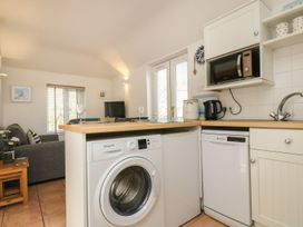 A kitchen with a washing machine and dishwasher at Tater-Du in Porthcurno
