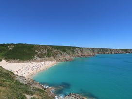 A beach with people at Porthcurno