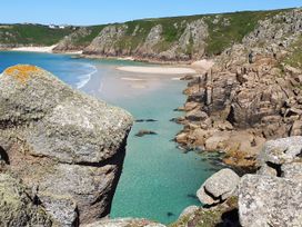 A beach with water and cliffs at Tater-Du in Porthcurno near Land’s End