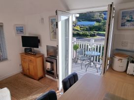 A living room with a television and a fireplace at Tater-Du in Porthcurno near Land’s End