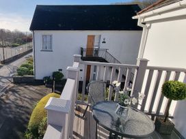 An outdoor balcony with a table and chairs at Tater-Du in Porthcurno near Land’s End