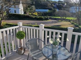 A balcony with a table and chair at Tater-Du in Porthcurno near Land’s End