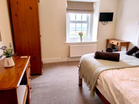 A bedroom with a bed, wardrobe, and window at Bush Nook House in Brampton