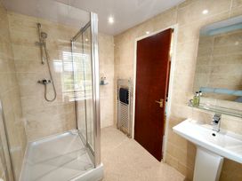 A bathroom with a shower, sink, and towel radiator at Bush Nook House in Brampton