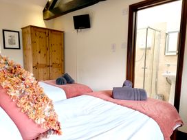 A bedroom with beds and an ensuite bathroom at Bush Nook House in Brampton