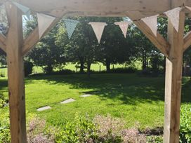 A garden view with bunting and a pathway at Bush Nook House in Brampton, Cumbria
