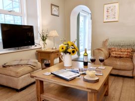 A living room with a television and a coffee table at Bush Nook House in Brampton, Cumbria