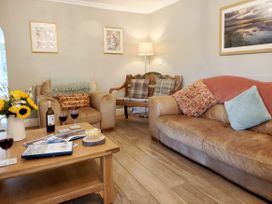 A living room with a sofa and armchair at Bush Nook House in Brampton, Cumbria