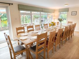 A dining room with a long table set for meals at Bush Nook House in Brampton, Cumbria